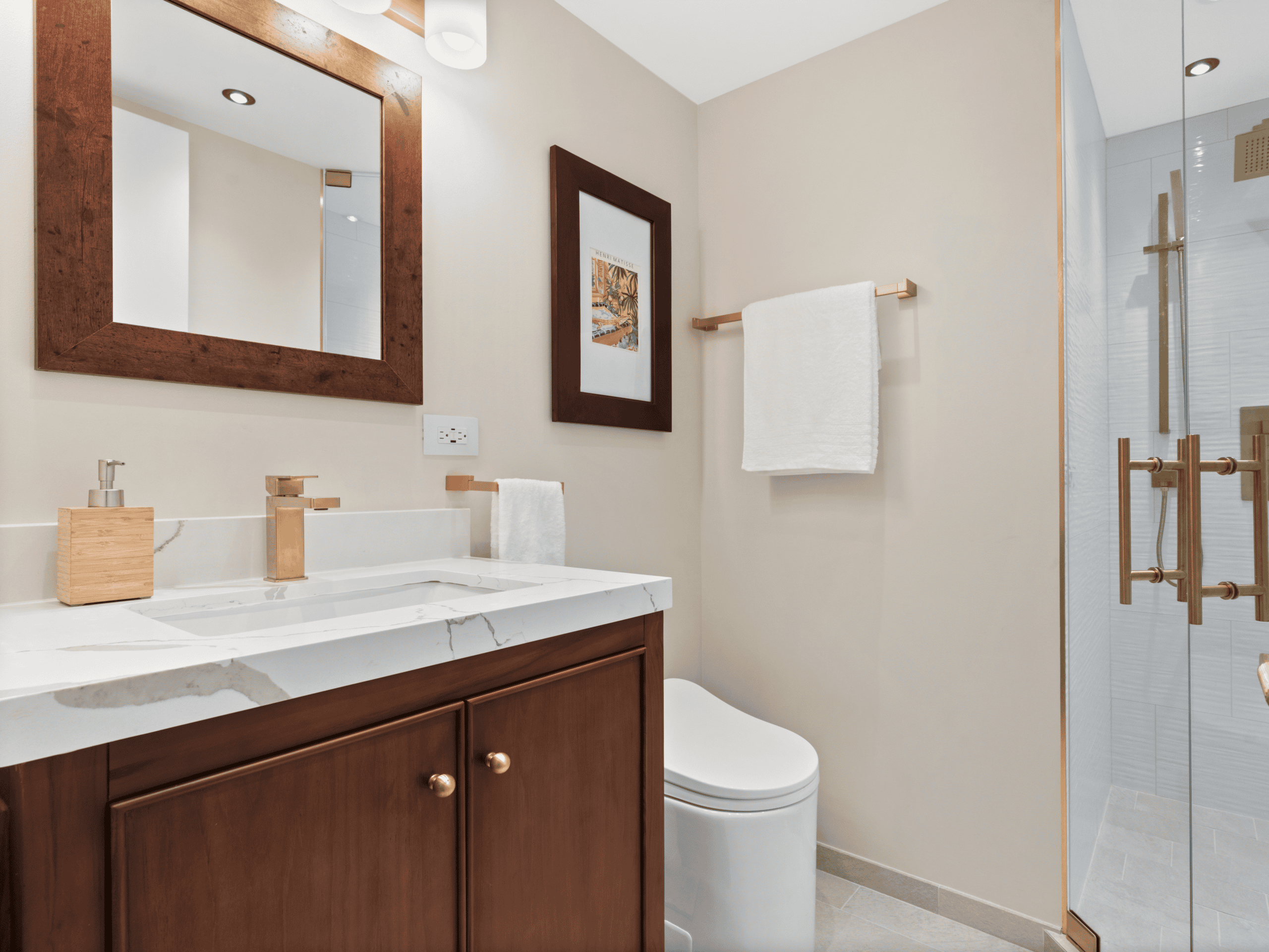 Elegant bathroom with wooden accents, marble countertop, and glass shower enclosure.