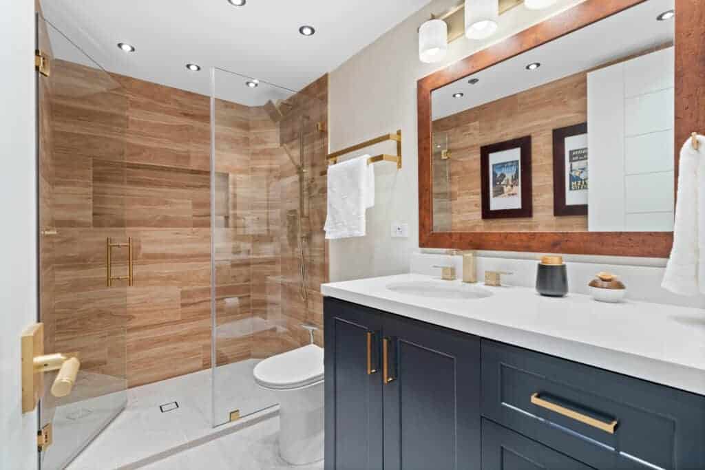 Contemporary bathroom with glass shower, navy vanity, and wooden accents.