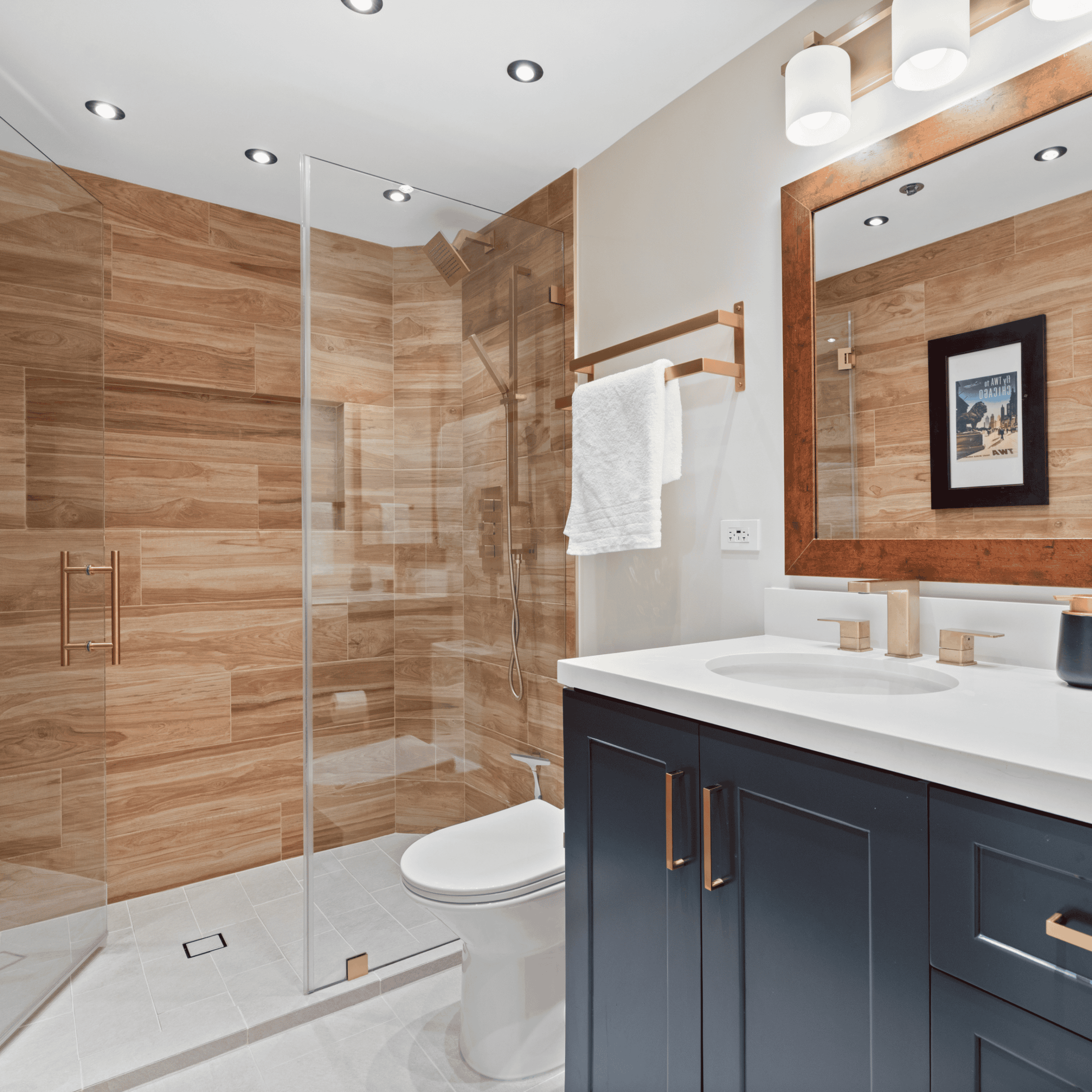 Contemporary bathroom with walk-in shower, navy vanity, and wooden accents.