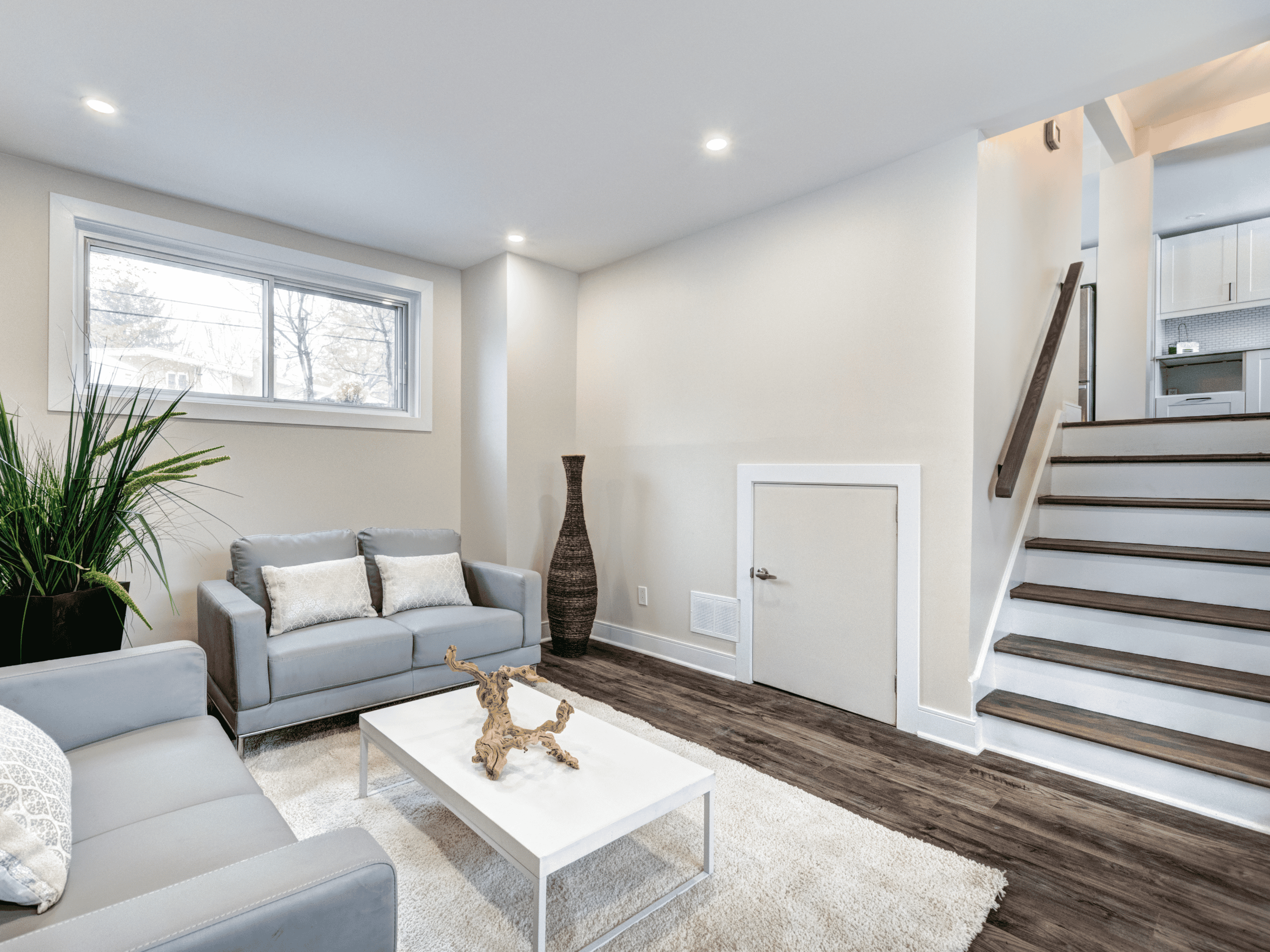 Modern Living Room Bright modern living room with gray sofas, white walls, and wooden flooring.