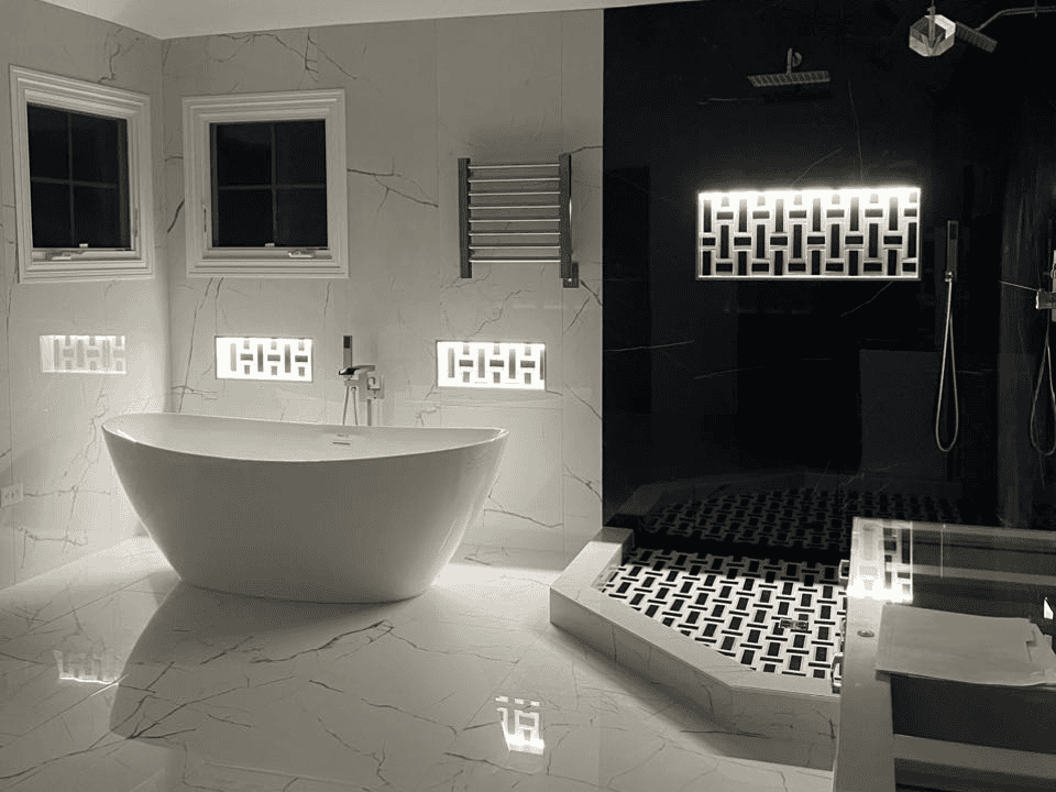 Modern bathroom with freestanding tub and walk-in shower with black and white tiles.
