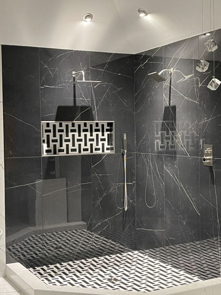 Modern black marble shower with dual shower heads and stylish tiling.