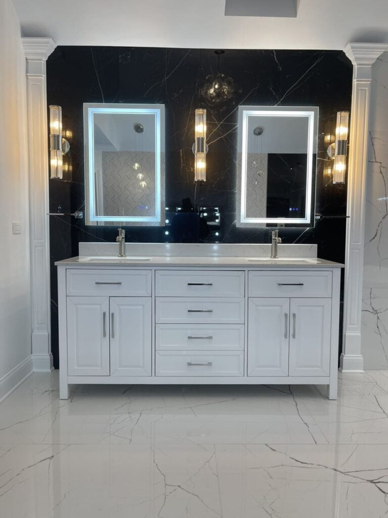 Double vanity with illuminated mirrors in a contemporary bathroom setting.