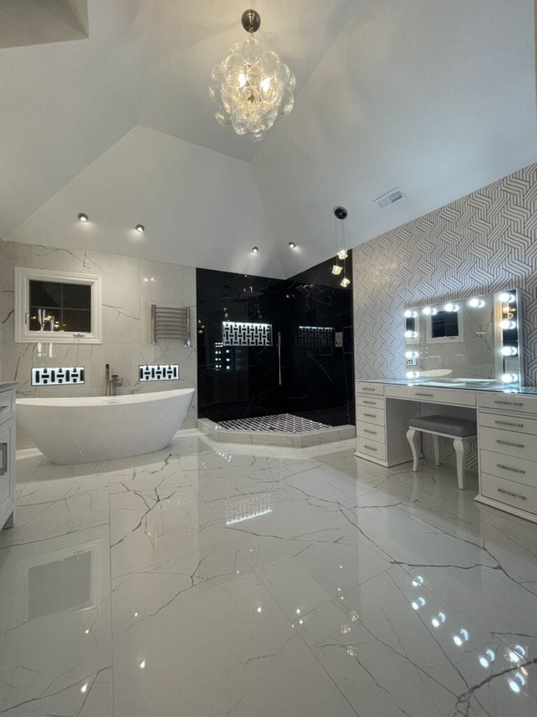 Modern luxury bathroom with bathtub, shower, and vanity with mirror lighting.