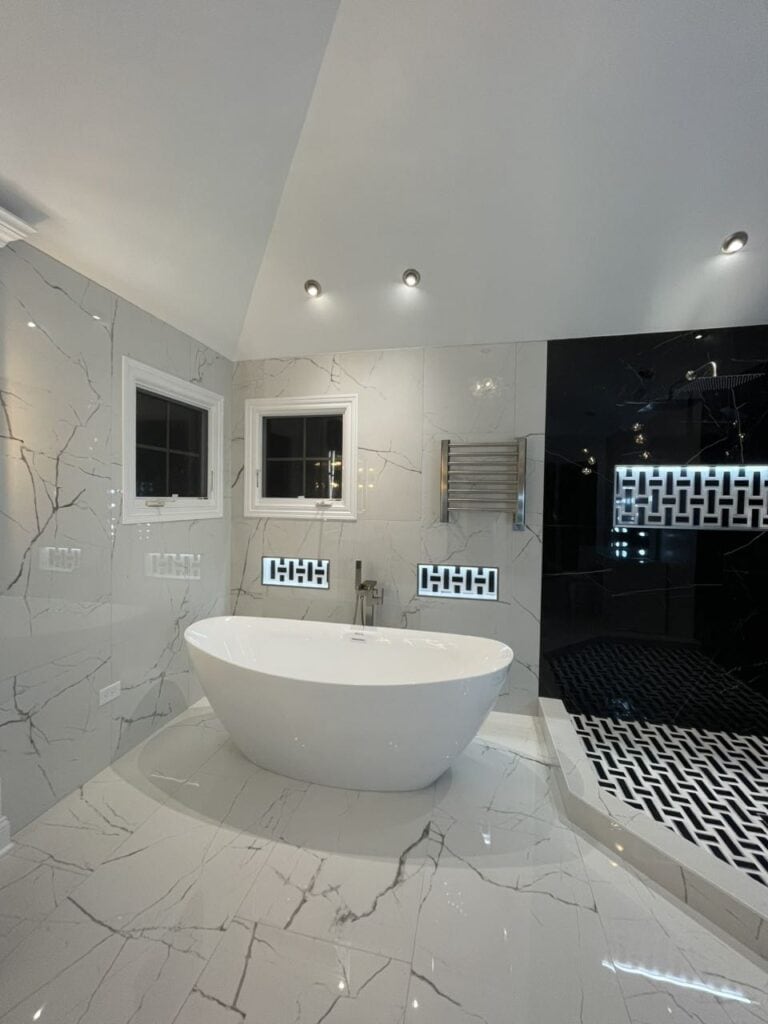 Modern bathroom with a freestanding bathtub and sleek black and white decor.
