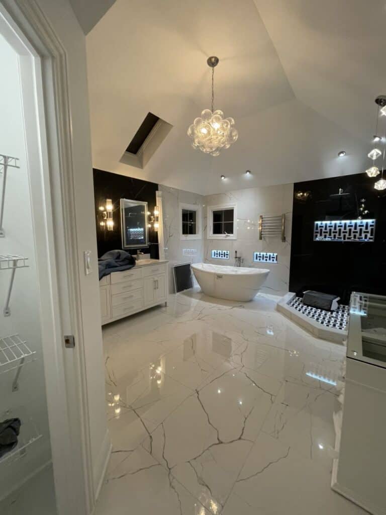 Elegant bathroom with modern fixtures, chandelier, and freestanding tub.