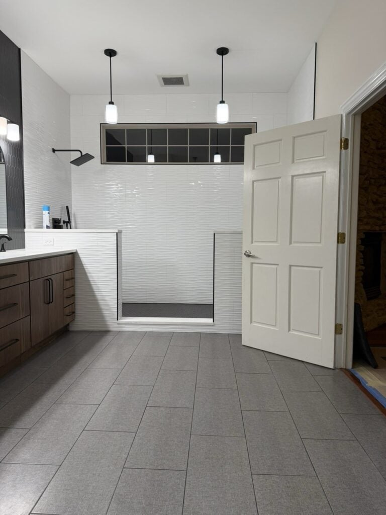 Contemporary bathroom with walk-in shower, white tiles, and modern fixtures.